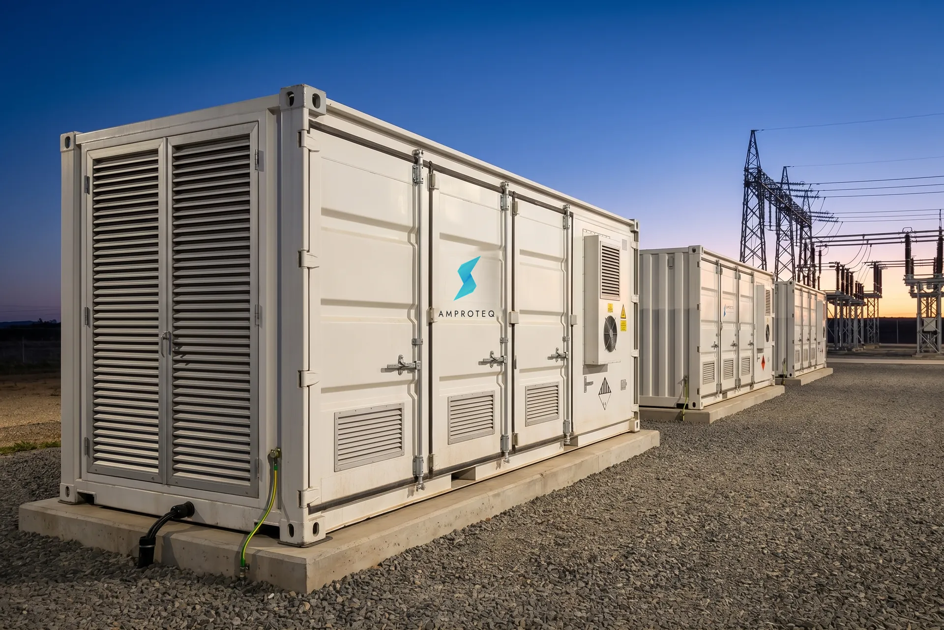 A row of AMPROTEQ battery containers at dusk at a utility storage plant
